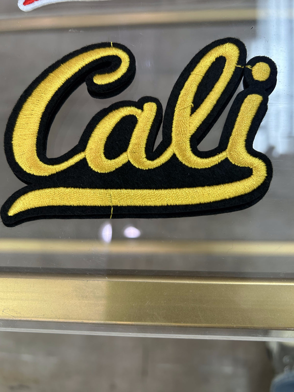 Cali script embroidered patch, black and gold